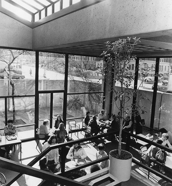 1970s modern room with dining tables, filled with students